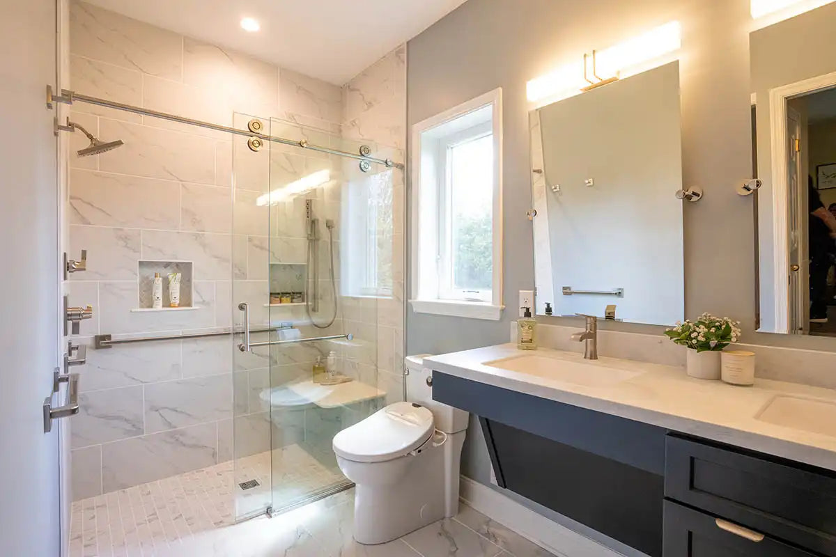 A modern bathroom with marble-look tiles, vanity storage, and barn door style shower doors for a sleek, space-saving design. |ACE DECOR