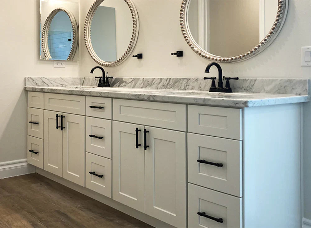 a beautifully designed bathroom featuring Shaker bathroom cabinets in a crisp white finish, paired with a marble countertop, black hardware, and elegant round mirrors. | ACE DECOR