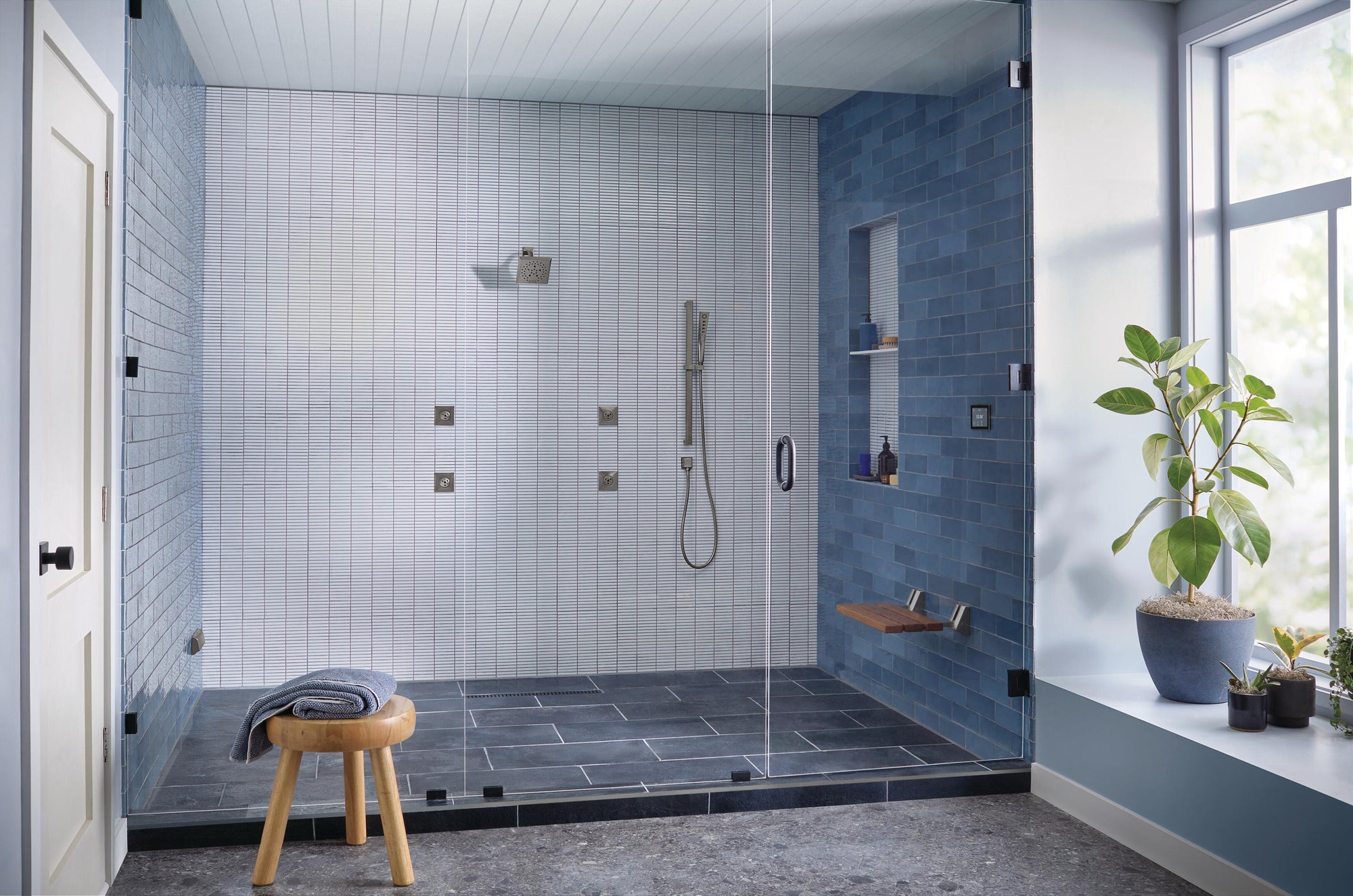 a modern steam shower system in a luxurious bathroom, featuring a sleek glass enclosure, stylish blue and white tiles, and built-in shower fixtures for a spa-like experience. | ACE DECOR
