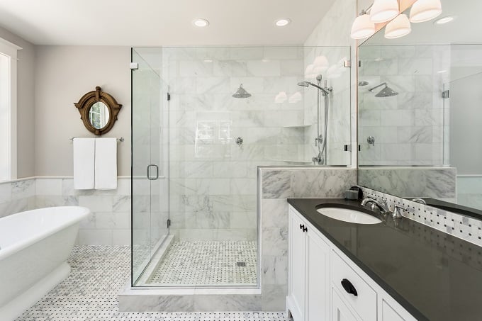 Elegant marble bathroom with a frameless glass enclosure and a custom shower base with tile