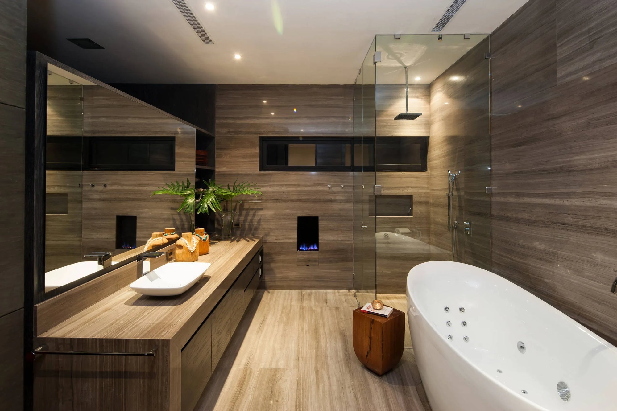 Modern spa with bathtub, wooden vanity, glass shower, and warm natural décor.