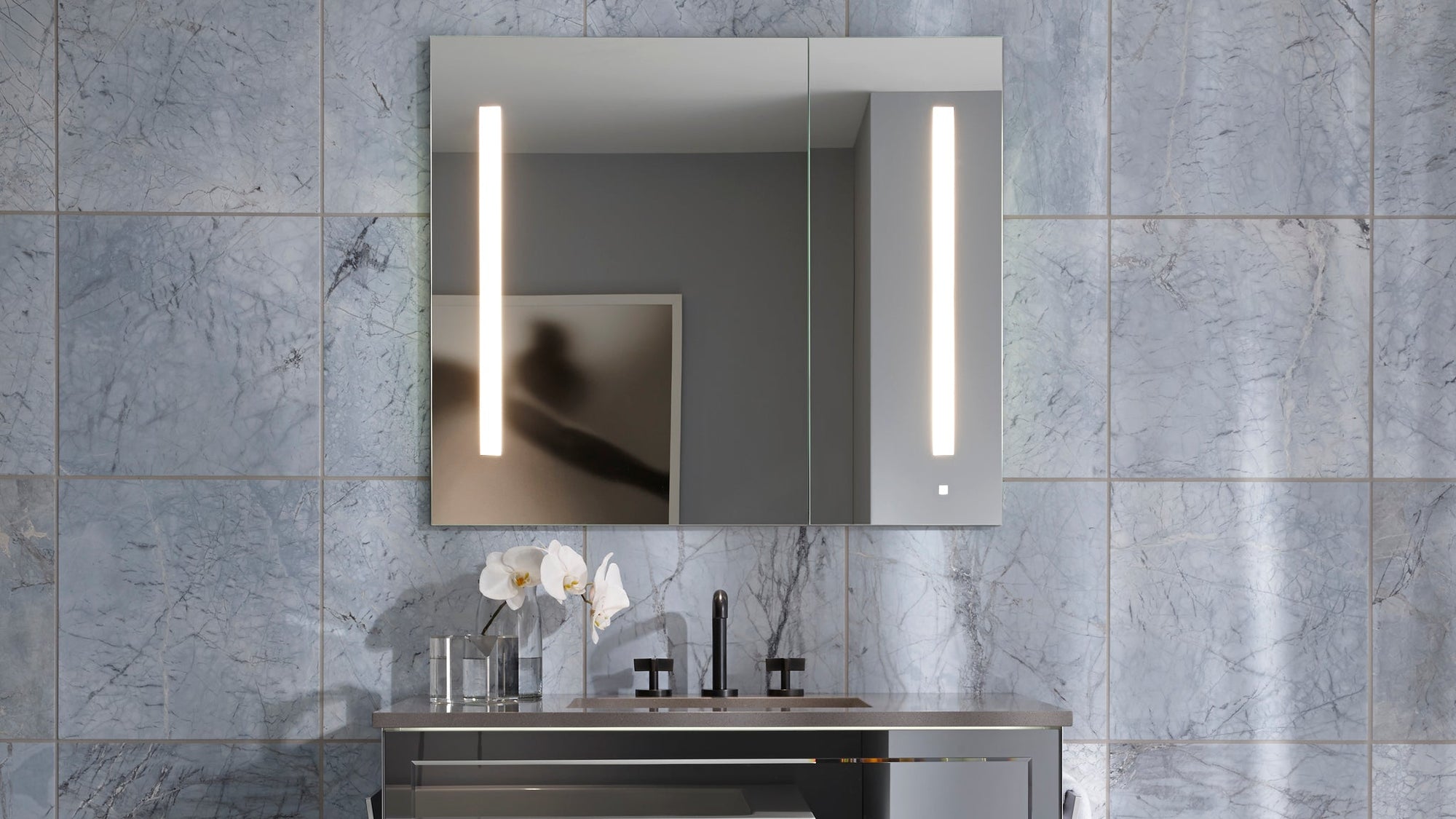 Modern medicine cabinet mirror with lights featuring vertical LED strips and a sleek double-door design.