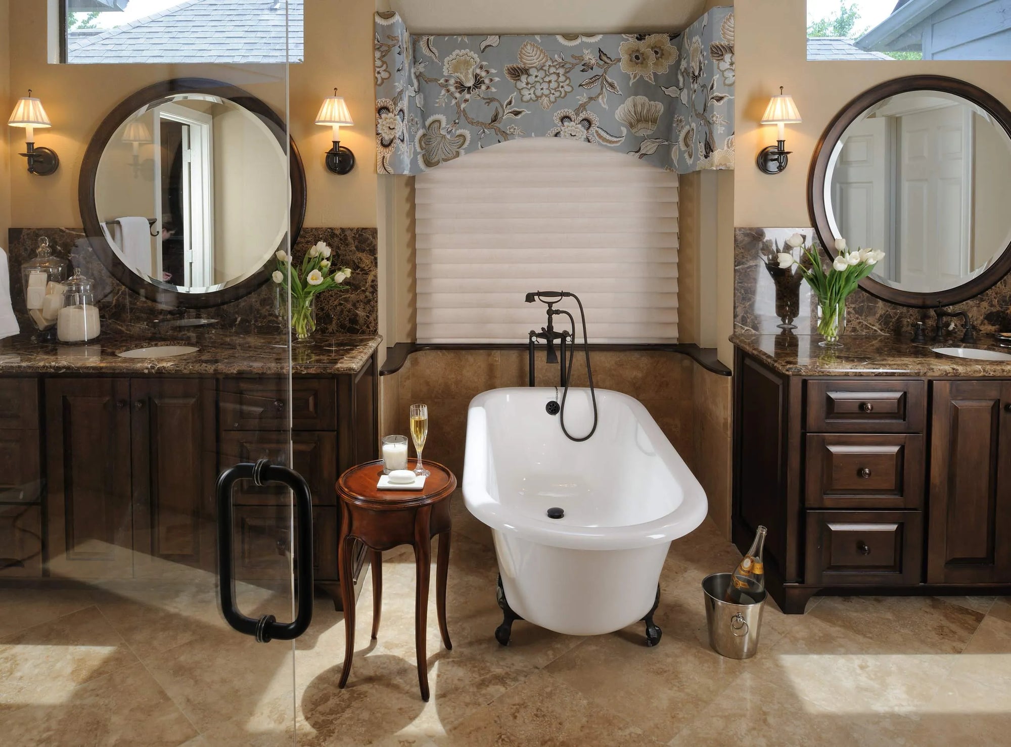 Black freestanding tub faucet in a luxurious bathroom with elegant wood cabinetry and marble countertops.