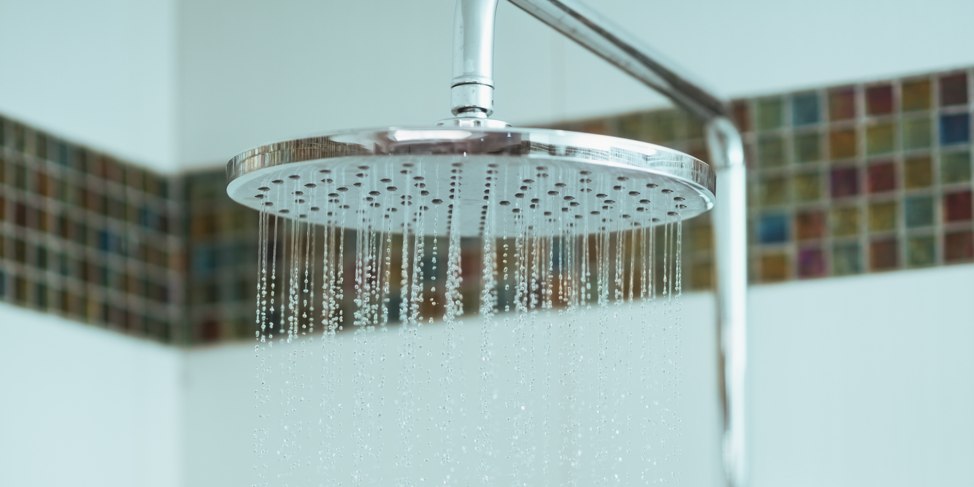 Close-up of a modern Shower System with Body Jets, featuring a rainfall showerhead with cascading water for a relaxing spa-like experience