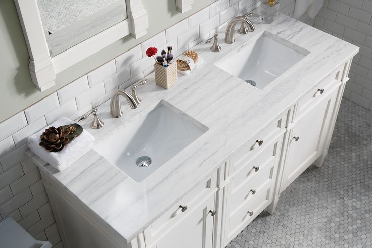 White double sink bathroom cabinet marble top with brushed nickel faucets and shaker-style drawers.