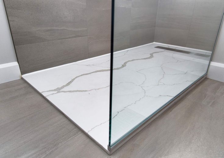 Stylish shower with a Quartz Shower Base and modern glass enclosure, featuring elegant marble design