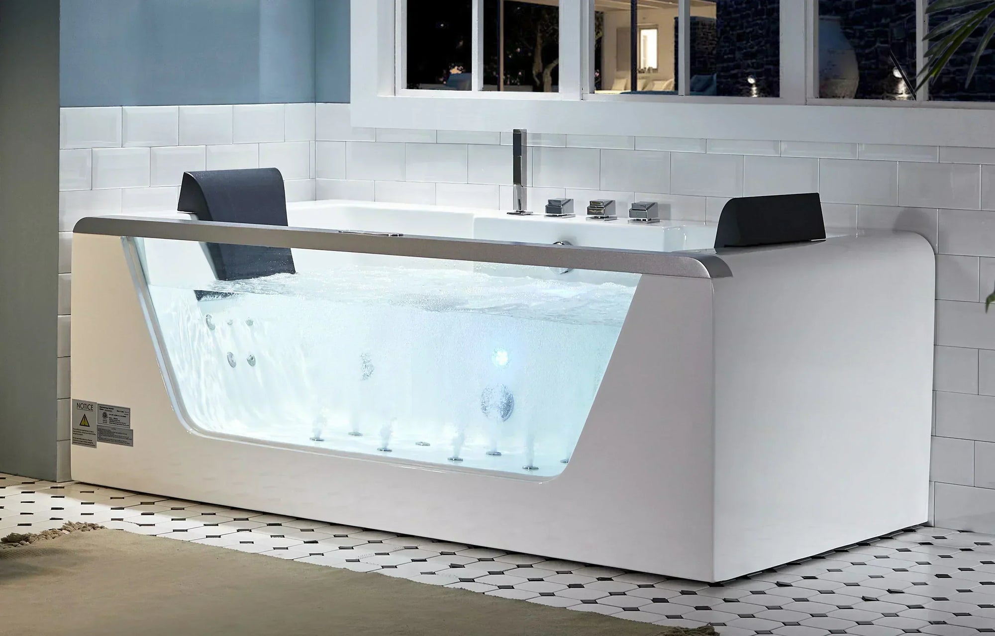 Modern white whirlpool bathtub with transparent front panel showcasing bubbling water jets, sleek design, silver faucet, and tiled bathroom setting.