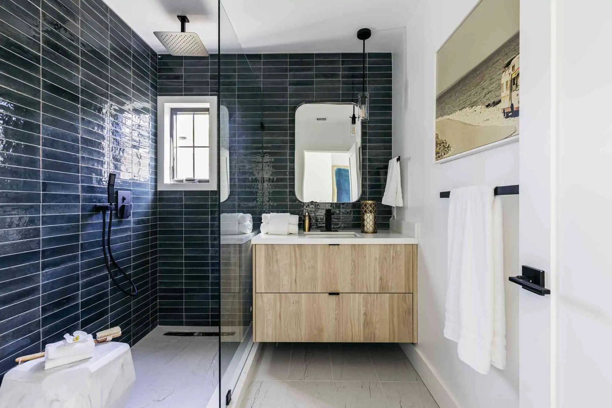 Modern walk-in shower door ideas with black tile walls and frameless glass panel in a minimalist bathroom