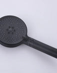 Front view of the matte black handheld shower head with a dark spray face and silicone nozzles.