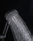 Auralen matte black handheld shower head delivering a mixed spray pattern.