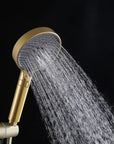 Brushed gold handheld shower head delivering a mixed spray pattern.