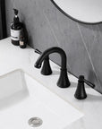 Top view of VALMIRA Matte Black Sink Faucet installed on marble vanity and gray wall backdrop.