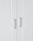Close-up of sleek metal door handle on tall white bathroom storage cabinet.