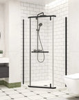 Contemporary black-frame shower enclosure featuring a matte finish, set in a clean, modern bathroom with black shower system.