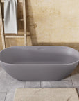 Nectar Series matte gray soaking tub in a bathroom with beige walls, wooden beam, towel rack, and gray tile flooring for a relaxing spa-like retreat.