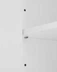 Close-up of adjustable shelf design inside white bathroom linen cabinet, showing customizable storage height.