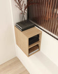 Angled view of light wood 12 inch wall-mounted bathroom storage cabinet with two open shelves.