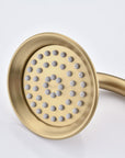 Close-up of the Avelar brushed gold handheld shower head showing silicone nozzles for easy cleaning.