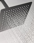 Lorton 12" black rain shower head in use with soft and full rainfall water flow.