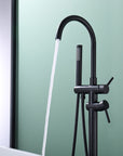Freestanding Black Tub Faucet with Handheld Shower in use, water flowing into bathtub.