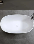 Top-down view of the white oval Lissome soaking bathtub with a modern tub faucet, installed on a grey minimalist floor.