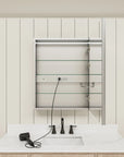 Open medicine cabinet with glass shelves and built-in outlet.