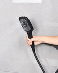 Matte black hand shower using the soft outer-ring spray mode.
