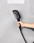 Matte black hand shower with all spray patterns activated for a full-coverage rinse.