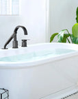 FLUNIX Matte Black Waterfall Roman Tub Faucet Set installed on freestanding bathtub.
