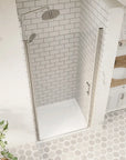 Top-down view of closed chrome framed pivot shower door in a tiled bathroom | Ace Decor