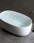 Lissome 47-inch solid surface stone resin freestanding oval bathtub with black tub faucet, ideal for small bathrooms.