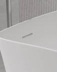Close-up detail of the 51" solid surface soaking bathtub's sleek overflow drain.