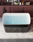 Glossy black surface of the Nectar Series freestanding tub, reflecting light on the marble surface.