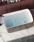 Nectar Series 49" black acrylic soaking tub filled with water on marble tile, with bath products.