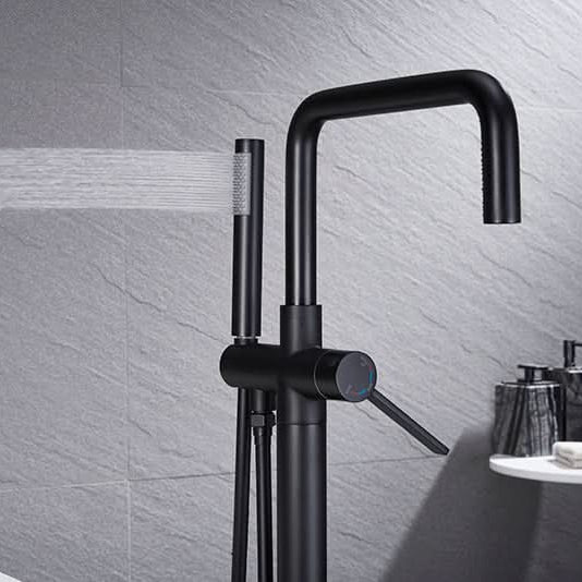 Black Freestanding Tub Faucet with handheld shower spraying water.
