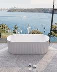 Nectar Series 67" soaking tub with circular rug and tub faucet in a minimalist bathroom featuring a panoramic harbor view.