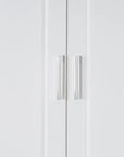 Stainless steel door handles on white tall bathroom linen cabinet, shown in close-up detail.