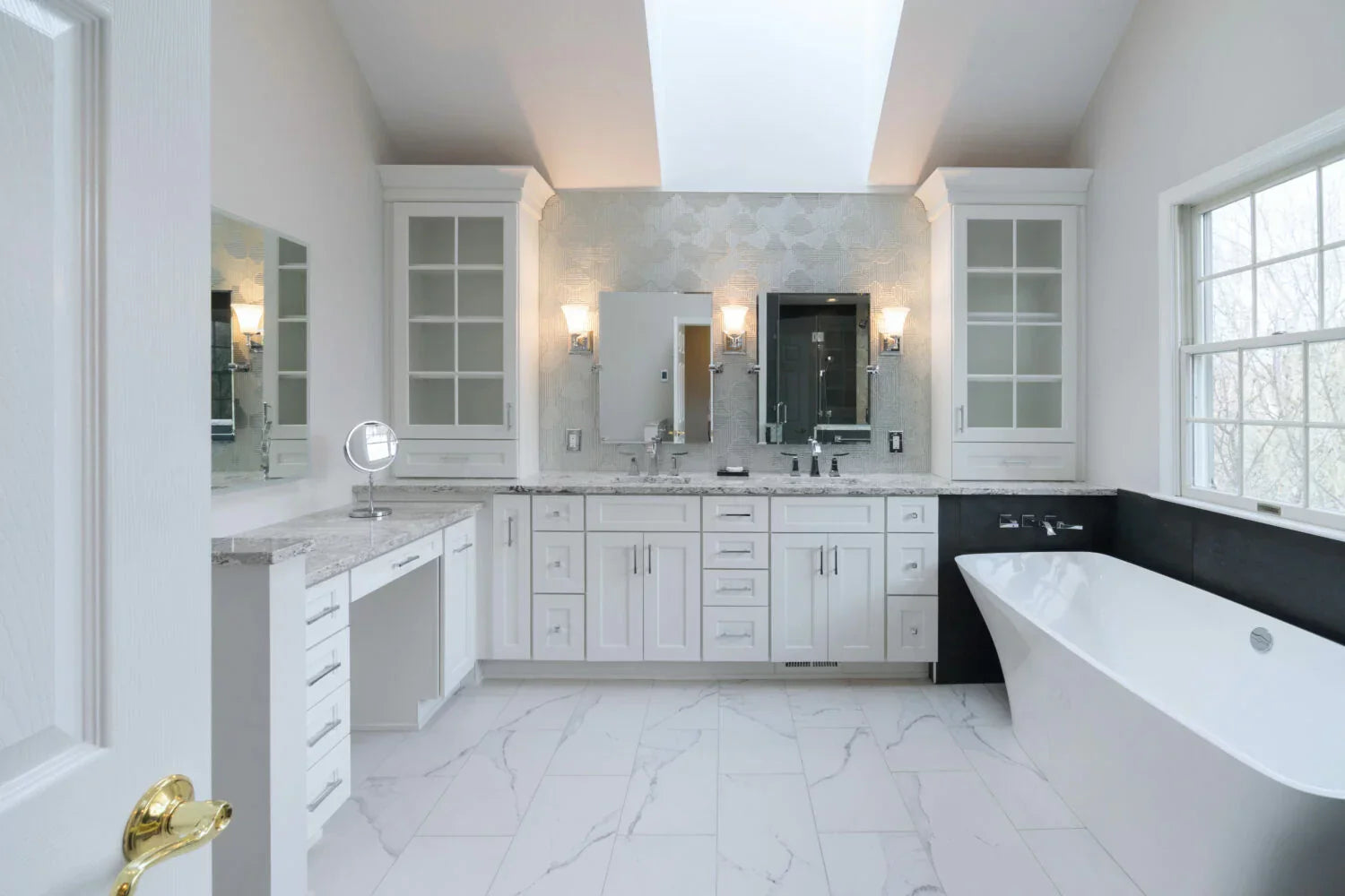 Spacious bathroom with L-shaped bathroom vanities, elegant marble countertops, and modern lighting