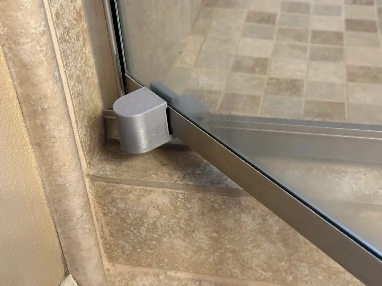 a Four Panel Shower Door Stop installed at the bottom corner of a glass shower door, ensuring controlled movement and stability. | ACE DECOR