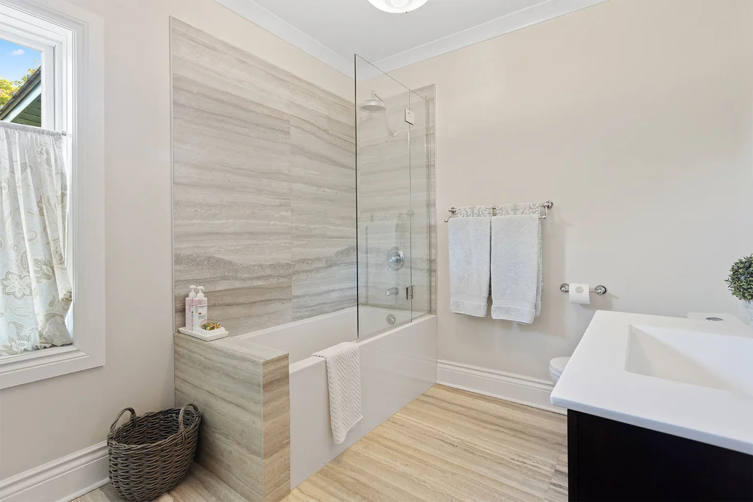 a modern bathroom with a sleek glass door on the bathtub, adding a clean and stylish touch to the space. | ACE DECOR