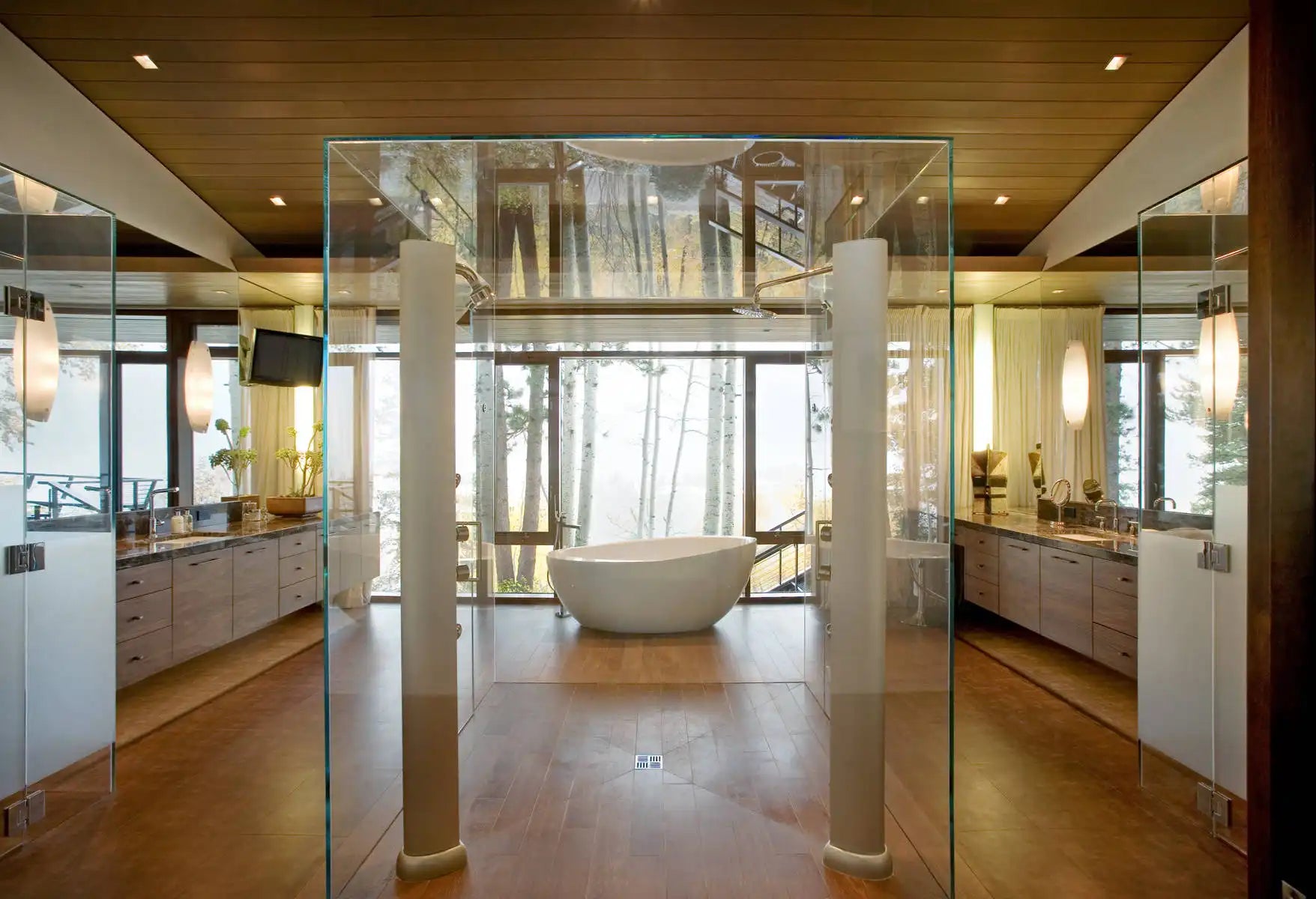 A luxurious bathroom featuring stunning **glass shower enclosures frameless**, warm wood accents, and a freestanding tub with a forest view. | ACE DECOR