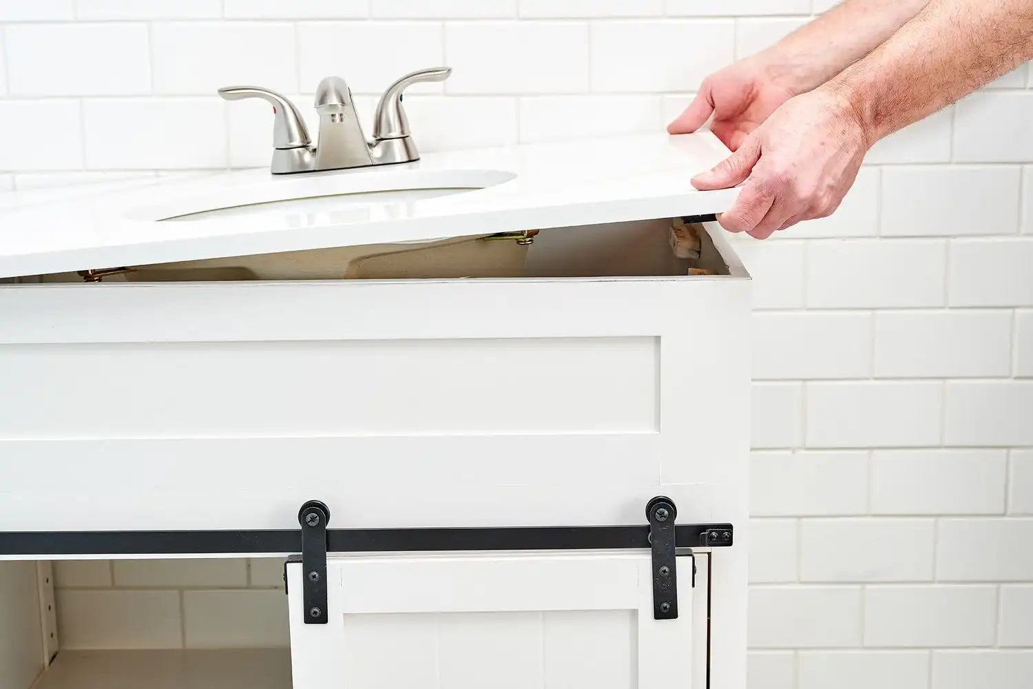 A person demonstrating how to install bathroom vanity by carefully placing the vanity top onto the cabinet. | ACE DECOR