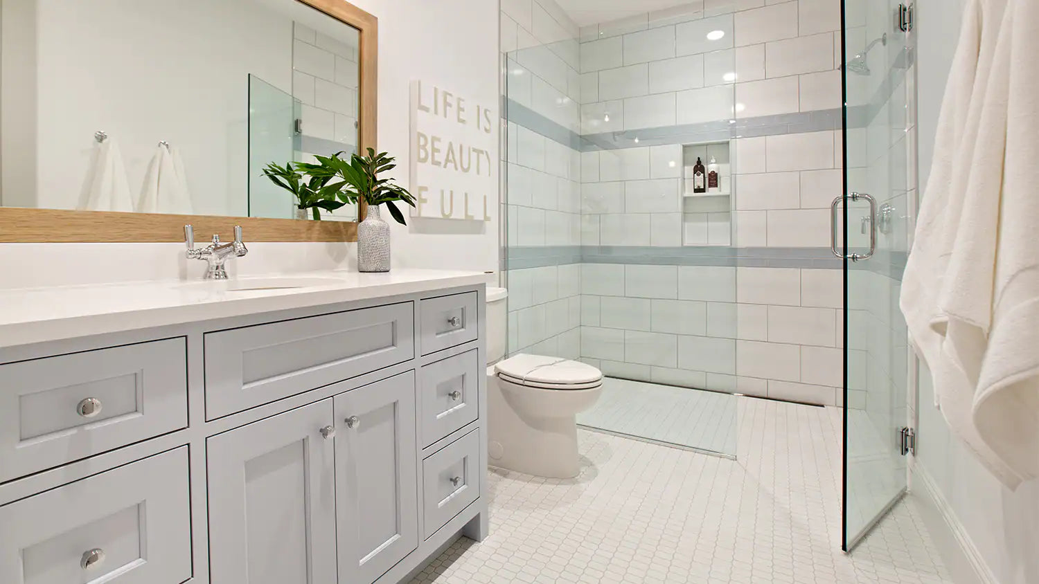 a bright and modern bathroom featuring a pivot swing shower door, a sleek vanity with a large mirror, and a spacious walk-in shower with built-in shelving. | ACE DECOR