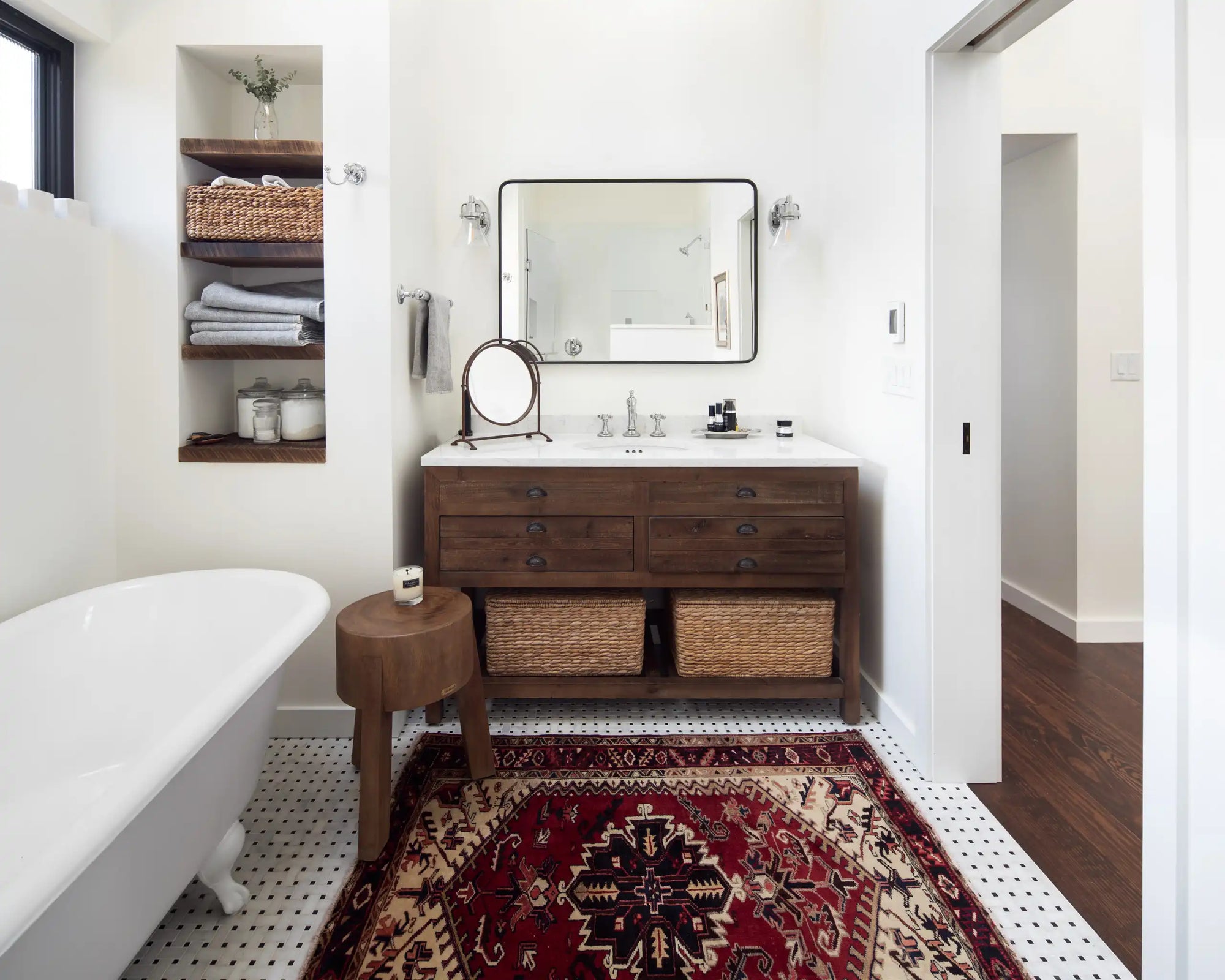 A cozy, modern bathroom featuring a **freestanding bathroom vanity with sink** in warm wood tones, paired with woven baskets and a vintage rug for a lived-in, collected feel. | ACE DECOR