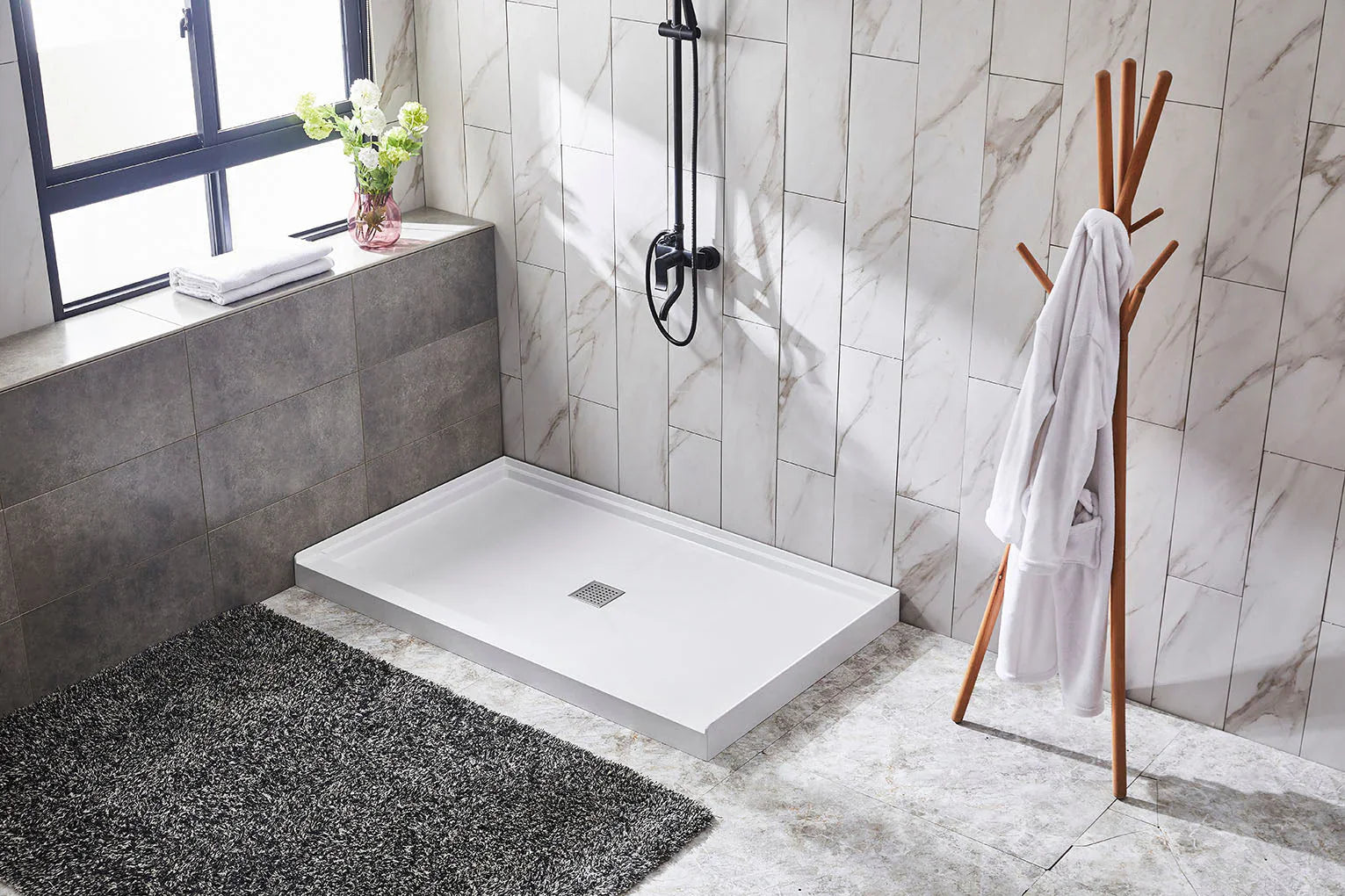 a modern bathroom with a sleek white shower base, marble-like wall tiles, and a minimalistic design featuring a towel rack and a gray rug. | ACE DECOR