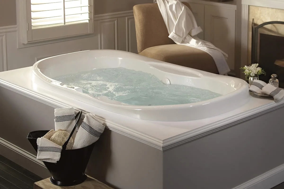 a luxurious jetted bathtub filled with water, positioned in a stylish bathroom setting. | ACE DECOR