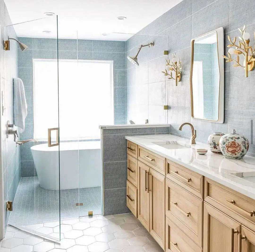 A serene modern bathroom featuring a bathtub in shower enclosure, light wood cabinetry, and elegant gold accents. | ACE DECOR
