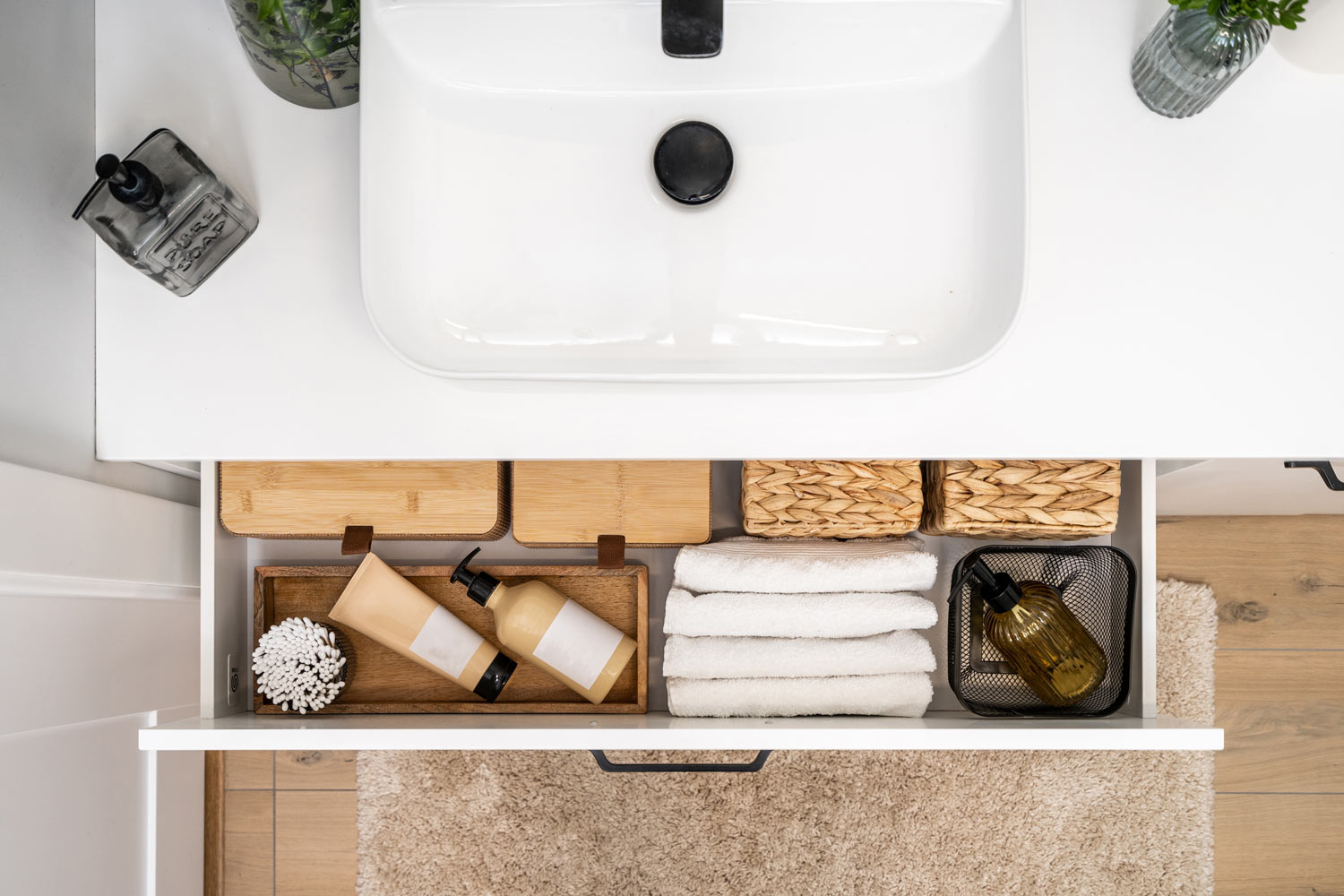 A neatly organized vanity drawer answers the question, "Should I put anything below bathroom cabinets?" with stylish, functional storage solutions. | ACE DECOR