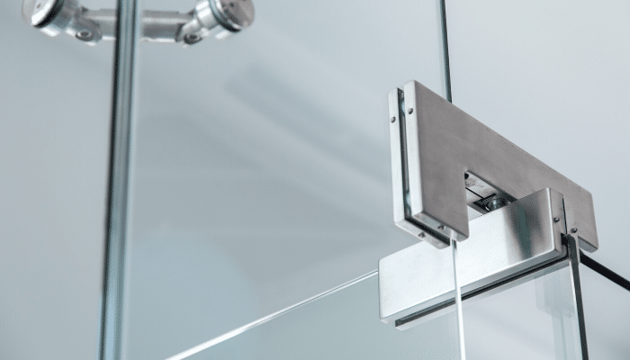Close-up view of a modern frameless shower door hinge—perfect visual for a guide on How to Adjust Glass Shower Door Pivot Hinge. | ACE DECOR