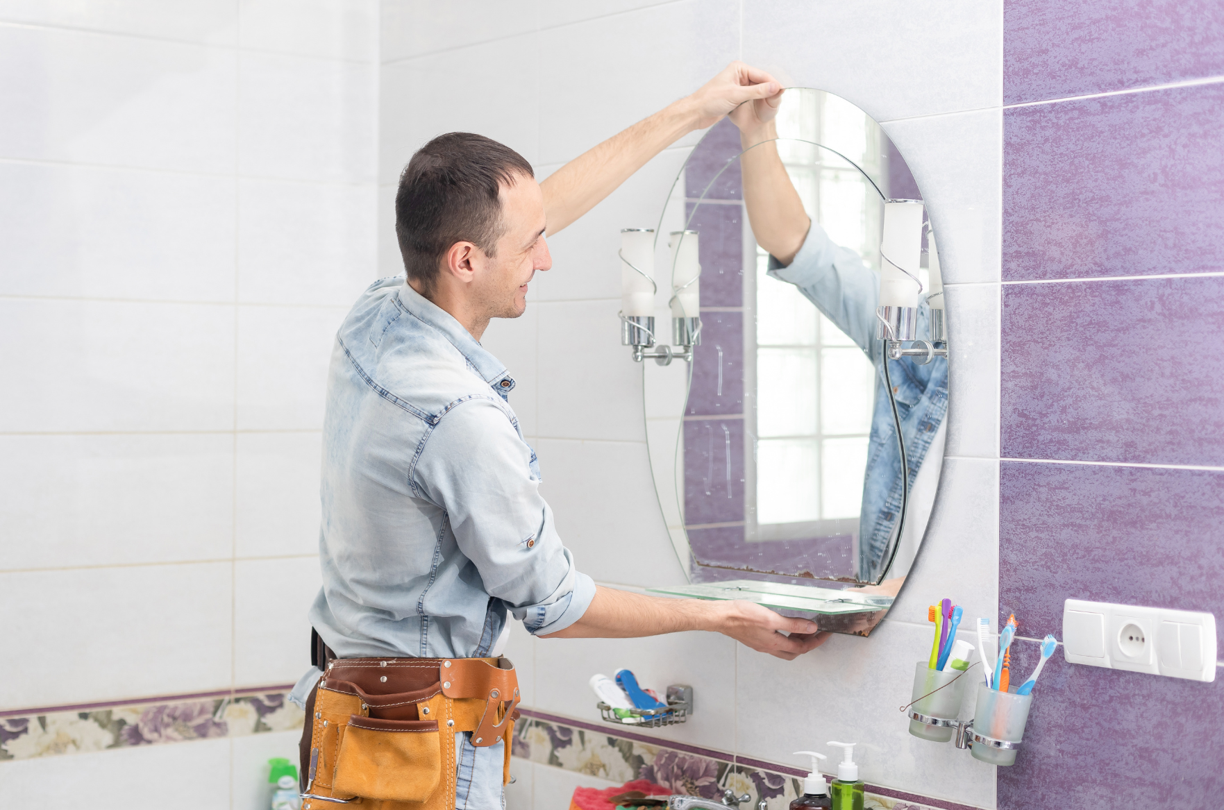 a man is installing a bathroom mirror | ACE DECOR